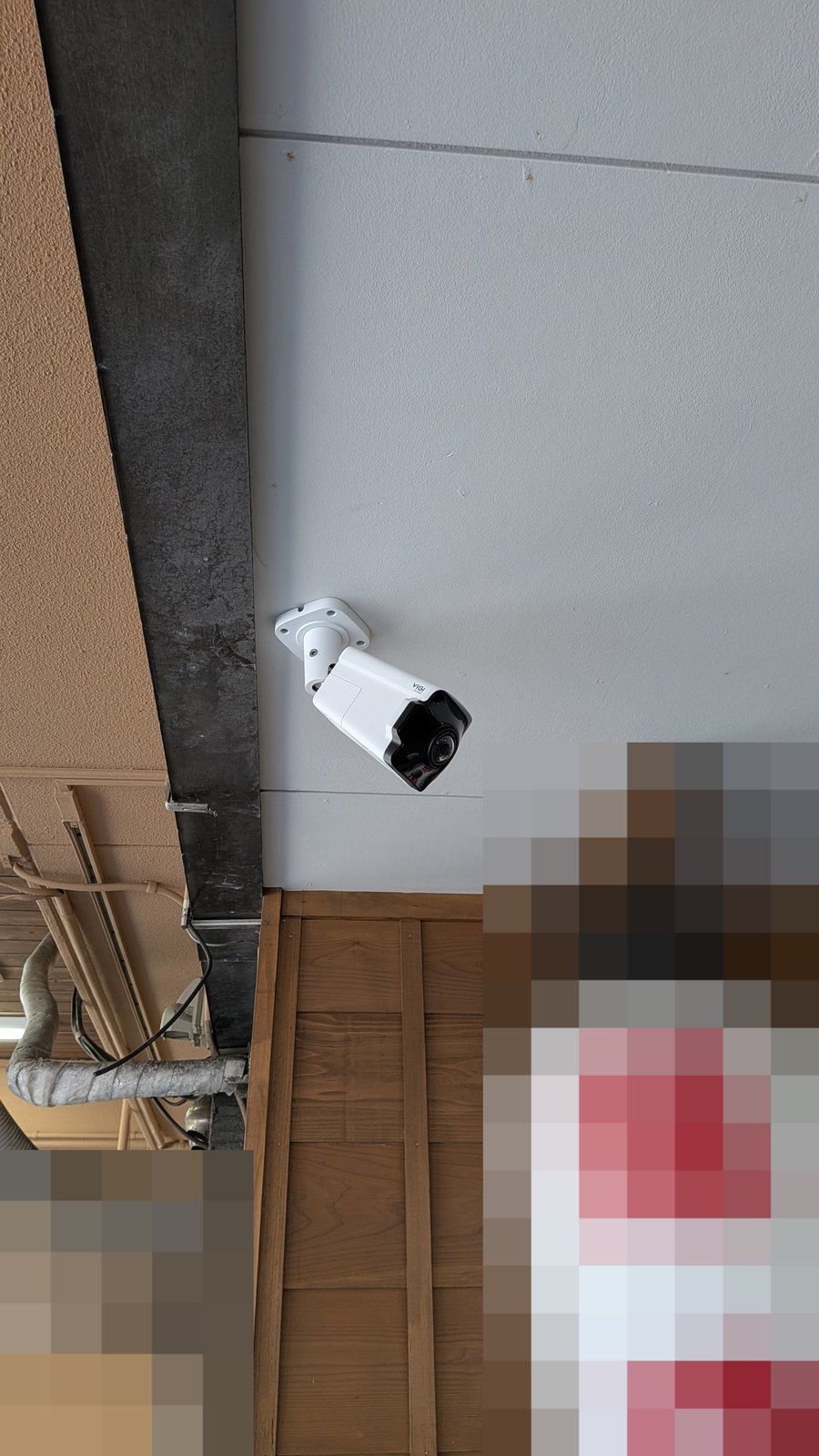 屋外の軒下に設置し、向きを合わせたバレット型の防犯カメラ